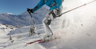 Man freeride skier running downhill on sunny Alps slope.